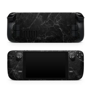 May include: A black handheld gaming console with a black and white marble pattern. The console has a screen, buttons, and joysticks.