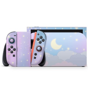 May include: A Nintendo Switch console and Joy-Con controllers with a pastel sky design. The controllers are lavender and blue with white stars. The console has a light blue background with a crescent moon and clouds.