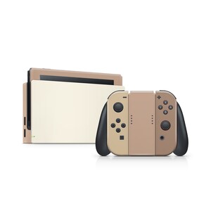 Pu&ograve; includere: Una console Nintendo Switch beige con un controller Joy-Con beige abbinato. La console ha uno schermo bianco e il controller ha pulsanti neri.