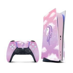 May include: A pink and purple PlayStation 5 console and controller with a unicorn design. The console has a gradient background with clouds and the controller has a unicorn head in the center.