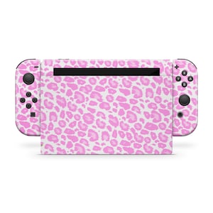 May include: Pink and white leopard print Nintendo Switch console skin. The skin covers the console, the joy-cons, and the back of the console.