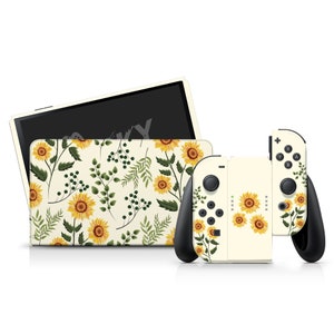 May include: A set of cream-colored gaming console accessories featuring a sunflower and foliage pattern. The set includes a console cover and two controllers. The design incorporates yellow sunflowers, green leaves, and berries on a cream background.