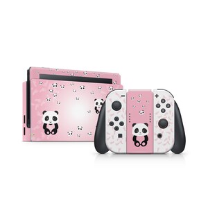 May include: Pink Nintendo Switch console and Joy-Con controllers with a panda bear design. The console and controllers are covered in a pink and white pattern with small panda bear faces.