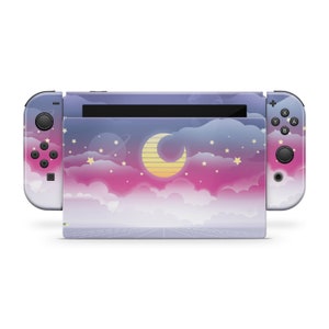 May include: A purple, pink, and blue Nintendo Switch console skin with a crescent moon, stars, and clouds. The skin is designed to look like a night sky.