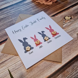 May include: A white card with the text "Happy Easter Judol Family" and four bunny silhouettes with buttons. The bunnies are labelled "Stuart", "Juliet", "Austin", and "Christina".