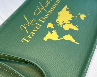 May include: Green travel document holder with a gold outline of a world map and the text "Miss Hunt's Travel Documents".