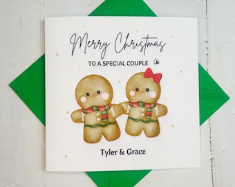 May include: A white Christmas card with a green envelope. The card features a gingerbread couple with the text "Merry Christmas to a special couple" and the names "Tyler & Grace".