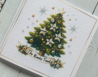 May include: A Christmas card with a festive design. It features a Christmas tree adorned with star-shaped ornaments, each bearing a name. A banner at the bottom reads "The Burke Family". The card has a gold border.