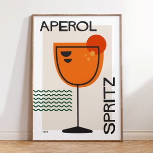 Può includere: Un poster in stile retrò con il testo "Aperol Spritz 1919" in nero. Il poster presenta un bicchiere arancione stilizzato con un cerchio rosso in cima, che rappresenta un cocktail Aperol Spritz. Lo sfondo è beige chiaro con linee ondulate verdi.
