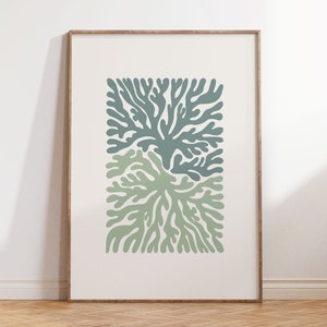 K&ouml;nnte beinhalten: Ein gerahmter Kunstdruck mit einem stilisierten botanischen Design. Das Kunstwerk zeigt zwei sich &uuml;berlappende korallenartige Formen in Gr&uuml;n- und Blaugr&uuml;nt&ouml;nen vor einem cremefarbenen Hintergrund. Der Rahmen hat einen warmen, nat&uuml;rlichen Holzton.