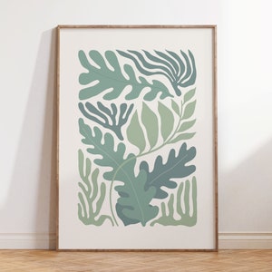 K&ouml;nnte beinhalten: Ein gerahmter botanischer Druck mit stilisierten gr&uuml;nen Bl&auml;ttern in verschiedenen Formen und Schattierungen auf cremefarbenem Hintergrund. Das Kunstwerk ist in einem hellbraunen Holzrahmen eingefasst, ideal f&uuml;r die Wanddekoration. Der Druck hat eine moderne, minimalistische &Auml;sthetik.
