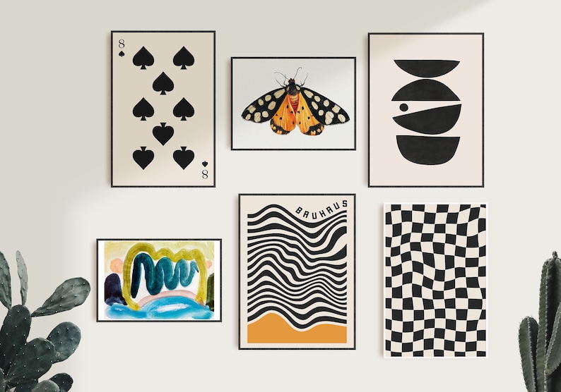 Op de afbeelding: Een galeriewand met negen ingelijste prints. De prints tonen abstracte ontwerpen, een vlinder, een speelkaart en een geruit patroon. De prints zijn in zwart, wit, oranje, geel, blauw en groen.
