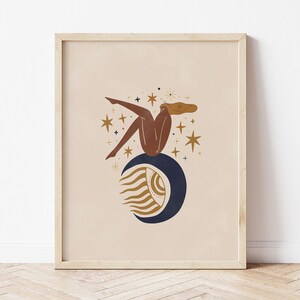 Può includere: Un'illustrazione digitale di una donna seduta su una luna crescente con un occhio stilizzato. La donna ha la pelle marrone e lunghi capelli castani. La luna è blu e ha un design dorato simile al sole. Lo sfondo è di colore pesca chiaro con stelle dorate.