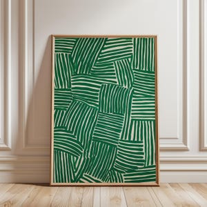 Può includere: Stampa artistica incorniciata con un motivo astratto di linee verdi curve su sfondo crema. L'opera d'arte è racchiusa in una sottile cornice di legno naturale, ideale per l'arredamento murale. Il design ha un'estetica moderna e geometrica.