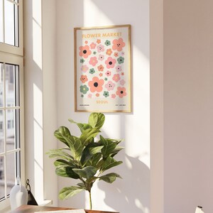 May include: A framed print with a white background and a colorful pattern of flowers. The print says "Flower Market Seoul" in a yellow font.