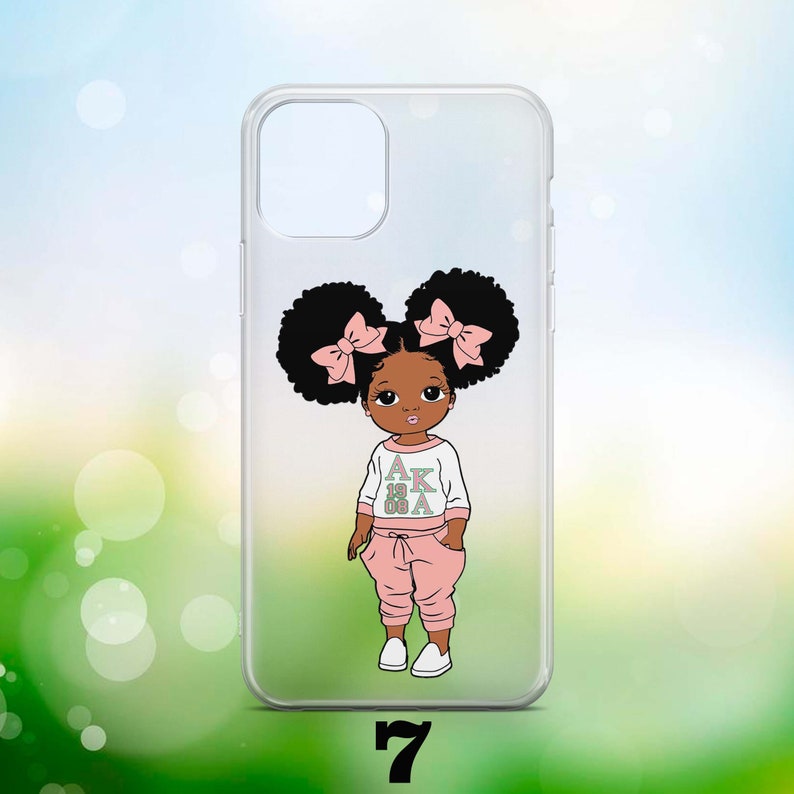 May include: A clear phone case featuring a cartoon illustration of a young Black girl with pink bows in her hair. She is wearing a white shirt with the letters "AKA 1908" printed on it and pink trousers.