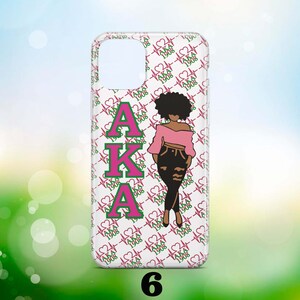 May include: A clear phone case with a pink and green "AKA 1908" pattern. A black silhouette of a woman is in the centre of the case.