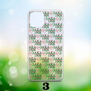 May include: A clear phone case with a repeating pattern of pink hearts and green text that says "AKA 1908".