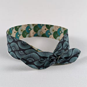 Op de afbeelding: Set van drie keramische mokken met een gespikkelde, crèmekleurige glazuur. Elke mok heeft een handgeschilderd bloemmotief in blauw, groen en geel. De mokken hebben een eenvoudige, afgeronde vorm en een oor.