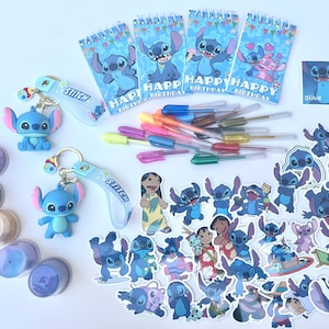 May include: A collection of Stitch-themed party supplies and stationery. Includes blue Stitch figurines, keychains, stickers, notebooks with "Happy Birthday" text, and colorful gel pens. Various shades of blue, purple, and yellow are present.