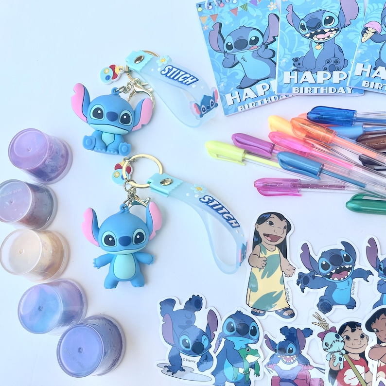 May include: A collection of Stitch-themed merchandise, including keychains, stickers, pens, and birthday cards. The keychains feature a blue Stitch figure with pink ears. The pens have colorful ink. The birthday cards have the words "Happy Birthday".