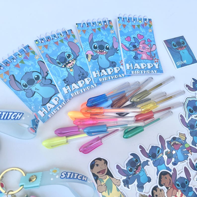 May include: A collection of Stitch-themed stationery and accessories. Includes spiral notebooks with "Happy Birthday" text and Stitch illustrations, colorful gel pens, stickers, and a keychain. The items are arranged on a white surface.