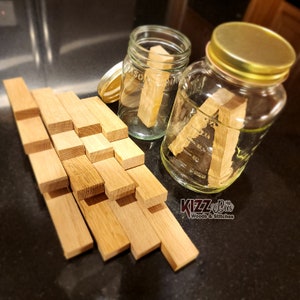 May include: A collection of wooden dowels in various sizes, stacked in a triangular shape. Two glass jars with lids are filled with water and contain wooden dowels. The jars are labeled "Mason" and the text "KizzBee Woods & Stitches" is visible in the lower right corner.