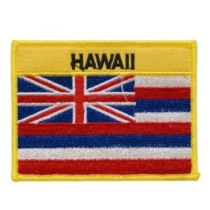 Op de afbeelding: Een gele geborduurde patch met de Hawaiiaanse vlag en het woord "HAWAII" in zwarte letters.