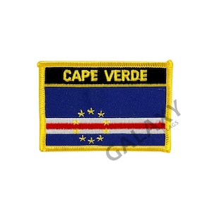 Puede incluir: Parche bordado con la bandera de Cabo Verde. La bandera es azul con una franja blanca y diez estrellas amarillas. El parche tiene un borde negro con las palabras "CAPE VERDE" en amarillo.