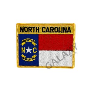 May include: Embroidered patch featuring the North Carolina state flag. The flag is a white field with a red band at the top and a blue square in the upper left corner. The blue square contains a white star and the letters "N.C." surrounded by a white circle with the words "May 20th 1775" and "April 12th 1776".