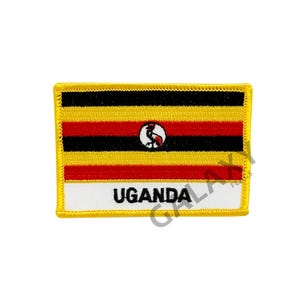 Könnte beinhalten: Ein gelber gestickter Aufnäher mit der Flagge Ugandas. Die Flagge hat sechs horizontale Streifen in Schwarz, Gelb, Rot, Gelb, Schwarz und Gelb. In der Mitte der Flagge befindet sich ein roter Kreis mit einem schwarzen Kranich. Die Worte "UGANDA" sind in Schwarz auf weißem Hintergrund am unteren Rand des Aufnähers gedruckt.