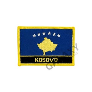 May include: A yellow embroidered patch with the flag of Kosovo. The flag is blue with a yellow outline of the country's shape and six white stars in a semi-circle. The words "KOSOVO" are embroidered in yellow on a black band at the bottom of the patch.