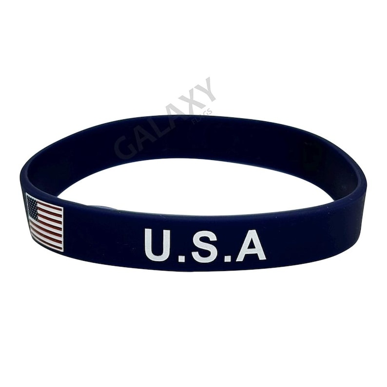 May include: A navy blue silicone bracelet with a white American flag and the text "U.S.A."