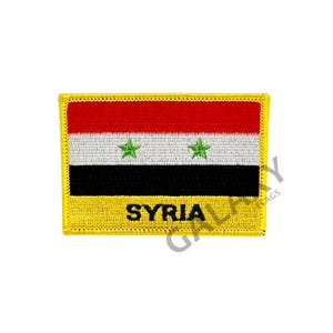 May include: A yellow embroidered patch featuring the flag of Syria. The flag has three horizontal stripes: red, white and black. The white stripe contains two green five-pointed stars. The patch has the word "SYRIA" written in black below the flag.