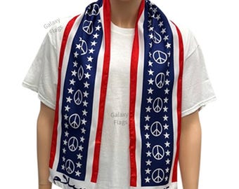 May include: A blue, red and white scarf with peace signs and stars. The scarf has the words "Peace" and "Salam" printed on it.