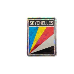 以下が含まれることがあります： 黒い文字で「SEYCHELLES」と書かれたホログラフィックステッカー。ステッカーには、青、黄、赤、白、黒の色で、セーシェルの国旗をスタイリッシュに表現しています。
