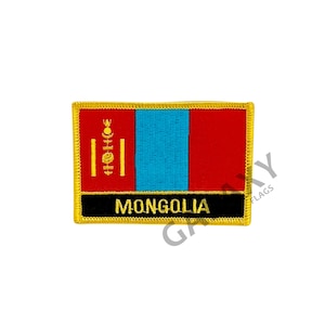 May include: A gold embroidered patch with the Mongolian flag. The flag features a vertical blue stripe with a red stripe on the right and a yellow symbol on the left. The patch has a black border with the word "MONGOLIA" in yellow letters.
