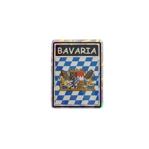 May include: A rectangular badge with the word "BAVARIA" at the top. The badge features a blue and white diamond pattern, a coat of arms with lions, and a silver border. The badge has a holographic effect.