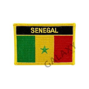 May include: Embroidered patch with the flag of Senegal. The patch is yellow with a green stripe on the left, a yellow stripe in the middle with a green star, and a red stripe on the right. The patch has a black border with the word "SENEGAL" in yellow letters.