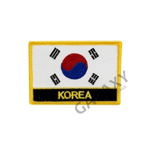 Może przedstawiać: Żółta naszywka haftowana z flagą Korei Południowej i napisem "KOREA" czarnymi literami.