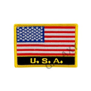 May include: A yellow embroidered patch with an American flag and the text "U.S.A." in black.
