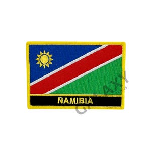 May include: Embroidered patch featuring the Namibian flag with a yellow border and the word "NAMIBIA" in gold lettering on a black background.