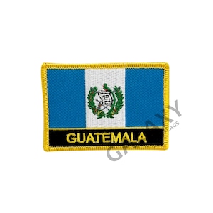 May include: Embroidered patch featuring the flag of Guatemala. The patch is rectangular with a blue, white, and blue horizontal stripe design. The center of the patch features the Guatemalan coat of arms. The patch has a black border with the word "GUATEMALA" in yellow lettering.