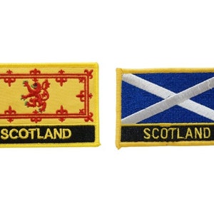 May include: Two embroidered patches featuring the flag of Scotland. The first patch features the Scottish Royal Arms with a red lion on a yellow background. The second patch features the Scottish Saltire, a white diagonal cross on a blue background. Both patches have a black border and the word "SCOTLAND" in yellow lettering.