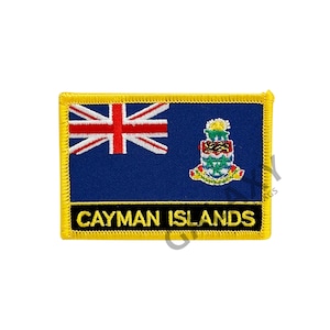 Puede incluir: Un parche bordado amarillo con la bandera de las Islas Caimán. La bandera es azul con una Union Jack en la esquina superior izquierda y el escudo de armas de las Islas Caimán en el centro. El parche tiene las palabras "Cayman Islands" en letras negras debajo de la bandera.