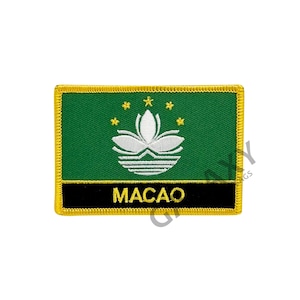 May include: A green embroidered patch with a white lotus flower and five gold stars. The patch has a black border with the word "MACAO" in white lettering.