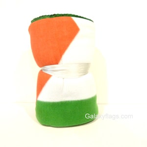 May include: A fleece blanket with the colors of the Irish flag: green, white, and orange. The blanket is folded in half and tied with a white ribbon. The text "Galaxyflags.com" is visible in the bottom right corner.