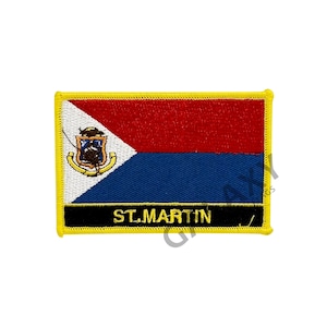 Op de afbeelding: Geborduurde patch met de vlag van Sint-Maarten. Het vlagontwerp bevat rode, witte en blauwe secties, met een wapenschild in de linkerbovenhoek. De tekst "ST. MARTIN" staat onderaan.