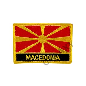 May include: A red and gold embroidered patch with the flag of North Macedonia and the word "MACEDONIA" in black lettering.