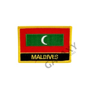 May include: A rectangular patch featuring the flag of the Maldives. The flag has a red background with a green rectangle in the center, displaying a white crescent moon. The word "MALDIVES" is printed in white on a black banner.
